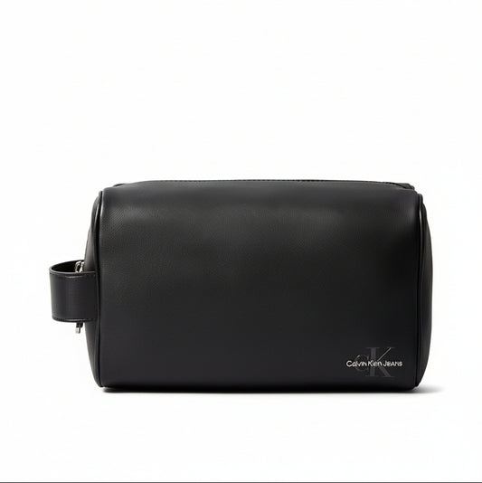 Black leather toiletry bag with Calvin Klein logo on a beige background
