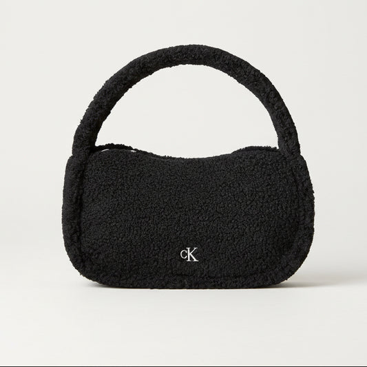 Black textured handbag with a brand logo on a beige background