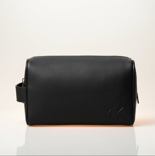Black leather toiletry bag on a beige background