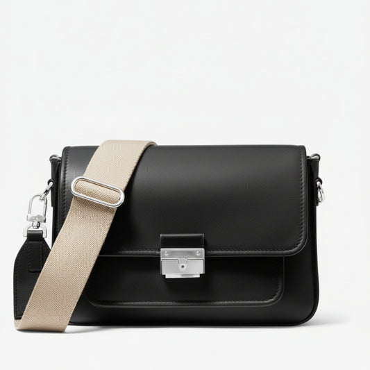 Black handbag with beige strap on a light gray background