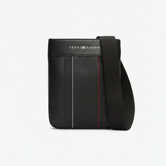 Black crossbody bag with red stitching and Tommy Hilfiger logo on a white background